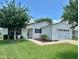 Home exterior featuring a well-maintained lawn and a one car garage at 3337 Candlebrook St, The Villages, FL 32162