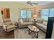 Living room boasts ample natural light, neutral furniture, ceiling fan, and stylish area rug at 3337 Candlebrook St, The Villages, FL 32162