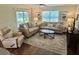Comfortable living room featuring neutral-toned sofas, a ceiling fan, and a decorative rug at 3337 Candlebrook St, The Villages, FL 32162