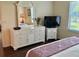 Bright main bedroom featuring a TV, dresser and nightstand for ample storage and entertainment options at 3337 Candlebrook St, The Villages, FL 32162