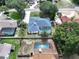 Aerial view of a home with a screened pool, palm tree, and adjacent well-maintained properties at 33913 Sabal Way, Leesburg, FL 34748