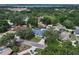 This aerial view shows a home with a blue roof, surrounded by lush trees at 33913 Sabal Way, Leesburg, FL 34748