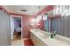 Bathroom featuring dual sinks, a large mirror, and access to the main bedroom at 33913 Sabal Way, Leesburg, FL 34748