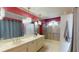 Bathroom with a dual sink vanity, large mirror, and a glass-enclosed shower with a seat at 33913 Sabal Way, Leesburg, FL 34748