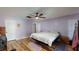 Spacious bedroom featuring hardwood floors, ceiling fan, and natural light from the window at 33913 Sabal Way, Leesburg, FL 34748
