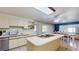 Well-lit kitchen with white cabinets, tile flooring, a large island, and a dining area with access to the patio at 33913 Sabal Way, Leesburg, FL 34748