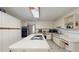 Bright kitchen featuring white cabinets, stainless steel appliances, a large island, and ample counter space at 33913 Sabal Way, Leesburg, FL 34748
