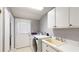 Laundry Room area equipped with a sink, cabinets, washer, and dryer at 33913 Sabal Way, Leesburg, FL 34748