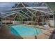 This covered patio features a private pool surrounded by lounge seating and a dining area at 33913 Sabal Way, Leesburg, FL 34748