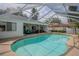 This covered patio features a private pool surrounded by lounge seating and a dining area at 33913 Sabal Way, Leesburg, FL 34748