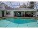 This covered patio features a private pool surrounded by lounge seating and a dining area at 33913 Sabal Way, Leesburg, FL 34748