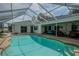 This covered patio features a private pool surrounded by lounge seating and a dining area at 33913 Sabal Way, Leesburg, FL 34748