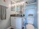 Cozy bathroom featuring a marble countertop, storage, and beach-themed decor at 3425 S Atlantic Ave # 1101, Daytona Beach, FL 32118
