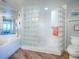 Bathroom showcasing tub and glass block shower, toilet, and decorative accents with wood-look floors at 3425 S Atlantic Ave # 1101, Daytona Beach, FL 32118