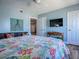 Bedroom featuring a queen bed, a ceiling fan, and a wall-mounted television at 3425 S Atlantic Ave # 1101, Daytona Beach, FL 32118