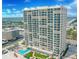 High-rise condo building with multiple balconies, a pool, and lush landscaping at 3425 S Atlantic Ave # 1101, Daytona Beach, FL 32118