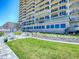 Lush green lawn with patio furniture and condo building at 3425 S Atlantic Ave # 1101, Daytona Beach, FL 32118