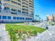 Well-maintained lawn with patio seating and landscaping near the condo building at 3425 S Atlantic Ave # 1101, Daytona Beach, FL 32118