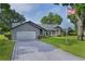 Charming single-story home with well-manicured lawn, decorative driveway, and an American flag at 36535 Eagle Dr, Grand Island, FL 32735