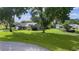 Expansive lot showcasing a well-maintained home with lush green grass and mature trees at 36535 Eagle Dr, Grand Island, FL 32735
