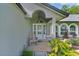 Inviting front porch with a decorative glass door, a rocking chair, and lush landscaping at 36535 Eagle Dr, Grand Island, FL 32735