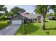 Charming single-story home featuring a well-manicured lawn, an American flag, and a spacious driveway at 36535 Eagle Dr, Grand Island, FL 32735