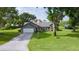 Charming single-story home featuring a well-manicured lawn, an American flag, and a spacious driveway at 36535 Eagle Dr, Grand Island, FL 32735