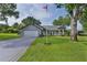 Charming single-story home featuring a well-manicured lawn, an American flag, and a spacious driveway at 36535 Eagle Dr, Grand Island, FL 32735