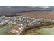 An aerial view of a community with ponds, showcasing homes with screened enclosures and varied architectural styles at 3769 Causey Ct, The Villages, FL 32163
