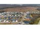 Aerial of an organized community with varied home designs, tree-lined streets, and a serene backdrop at 3769 Causey Ct, The Villages, FL 32163
