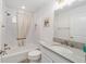 Bright bathroom offers tub with shower and granite counters on the vanity at 3769 Causey Ct, The Villages, FL 32163
