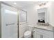 This bright bathroom has a glass shower with a grab bar, white vanity, and neutral finishes for easy cleaning at 3769 Causey Ct, The Villages, FL 32163