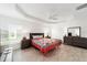 Bright bedroom features tray ceiling, ceiling fan, wood-look tile flooring, and natural light at 3769 Causey Ct, The Villages, FL 32163