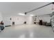 Spacious garage with epoxy flooring and overhead lighting offers ample space for vehicles and storage at 3769 Causey Ct, The Villages, FL 32163