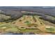 Aerial view of an 18-hole golf course highlighting its lush greens, winding paths, and landscape design at 3769 Causey Ct, The Villages, FL 32163