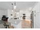 Modern kitchen features stainless steel appliances, white cabinetry, a spacious island, and stylish pendant lighting at 3769 Causey Ct, The Villages, FL 32163