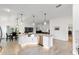 Kitchen island with white countertops and cabinets, stainless steel appliances, and open layout to the living area at 3769 Causey Ct, The Villages, FL 32163