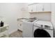 This laundry room features a new Samsung washer and dryer, tile flooring and cabinets for storage at 3769 Causey Ct, The Villages, FL 32163