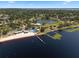Stunning aerial view of a lakefront beach community with a pier, pool, and sandy beach at 378 W Osceola St, Clermont, FL 34711
