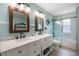 Bright bathroom featuring dual sinks, decorative mirrors, and a glass-enclosed shower at 378 W Osceola St, Clermont, FL 34711