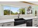 Kitchen with white countertops, stainless steel appliances, black sink, and a bright window view at 378 W Osceola St, Clermont, FL 34711