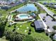 Aerial view showcases a community pool, bocce ball court, horseshoe pits, and a scenic pond at 3817 Miragalia Ln, The Villages, FL 32163