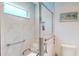 Bright bathroom featuring a tiled shower with glass door and convenient grab bars at 3817 Miragalia Ln, The Villages, FL 32163