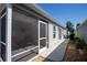 Screened-in porch alongside house with view of the backyard and trees at 3817 Miragalia Ln, The Villages, FL 32163
