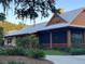 Attractive exterior of Fenney Grill featuring a metal roof, outdoor dining area, and manicured landscaping at 3817 Miragalia Ln, The Villages, FL 32163