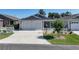Inviting home showcasing a spacious driveway, two-car garage, and well-manicured lawn at 3817 Miragalia Ln, The Villages, FL 32163