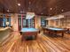 Fun game room with two pool tables, wood floors, ample seating and lighting, creating a social space at 3817 Miragalia Ln, The Villages, FL 32163