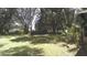 A serene backyard featuring mature trees, lush landscaping, and open green spaces, perfect for outdoor activities and relaxation at 3930 Griffin Ave, Lady Lake, FL 32159