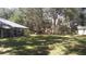 A sprawling backyard featuring lush green lawns, towering trees, and versatile outdoor spaces, ideal for nature lovers at 3930 Griffin Ave, Lady Lake, FL 32159