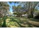 Lush backyard with mature trees, grassy areas, additional structures, and fenced perimeters at 3930 Griffin Ave, Lady Lake, FL 32159